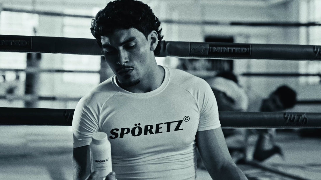 Fighter in a white Spöretz rashguard holding the MB40 bottle in a boxing ring, black-and-white